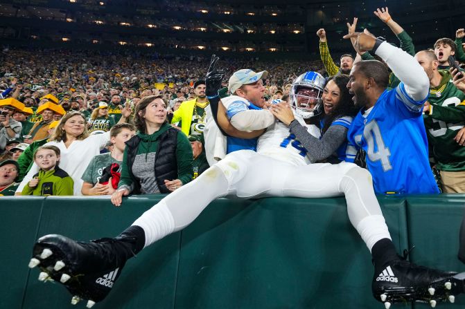 Amon-Ra St. Brown of the Detroit Lions celebrates with fans during his team's 34-20 victory over the Green Bay Packers at Lambeau Field on Thursday, September 28.
