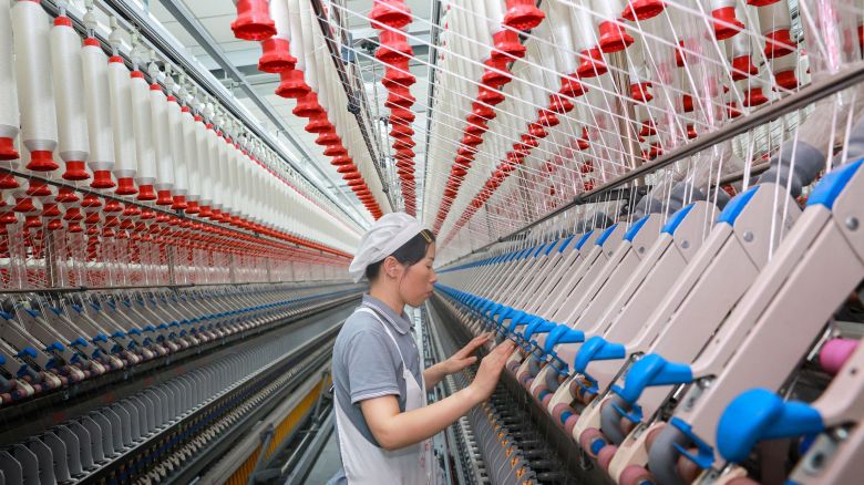 A worker operates machines at a texile factory in Nantong, in eastern China's Jiangsu province on September 14, 2023. 