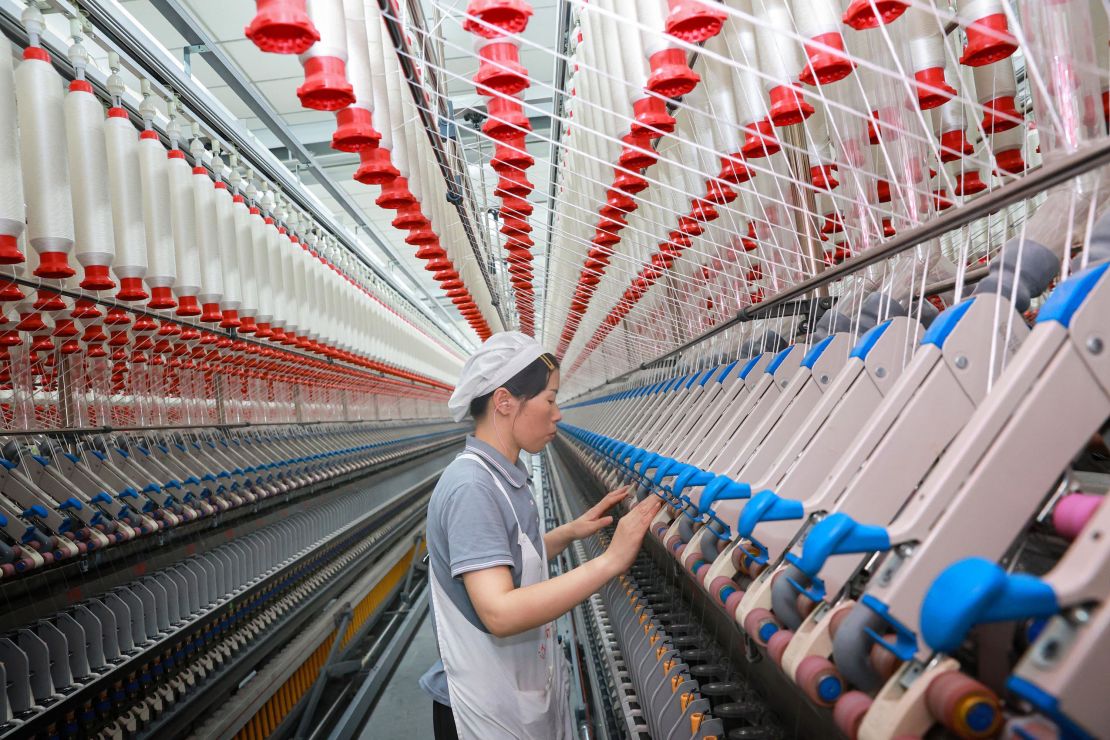 A worker operates machines at a texile factory in Nantong, in eastern China's Jiangsu province on September 14, 2023.
