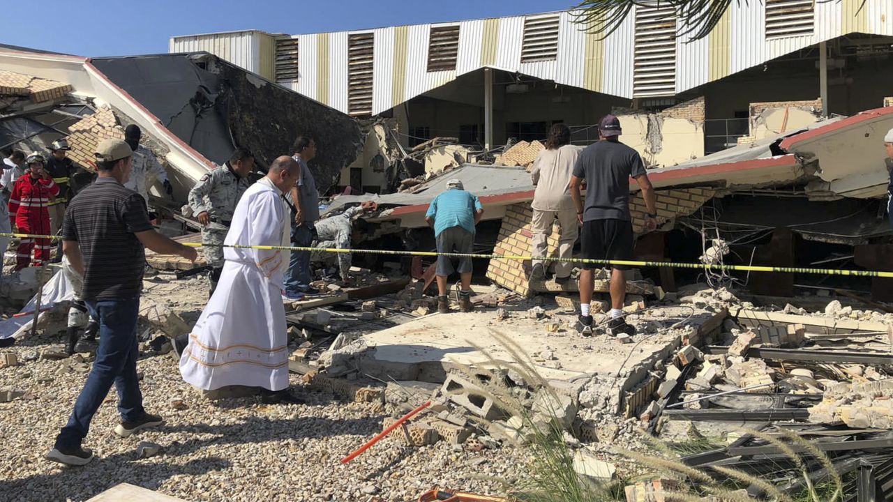 Security forces and a priest work at the site of a deadly church roof collapse in Ciudad Madero, in northern Mexico on October 1.