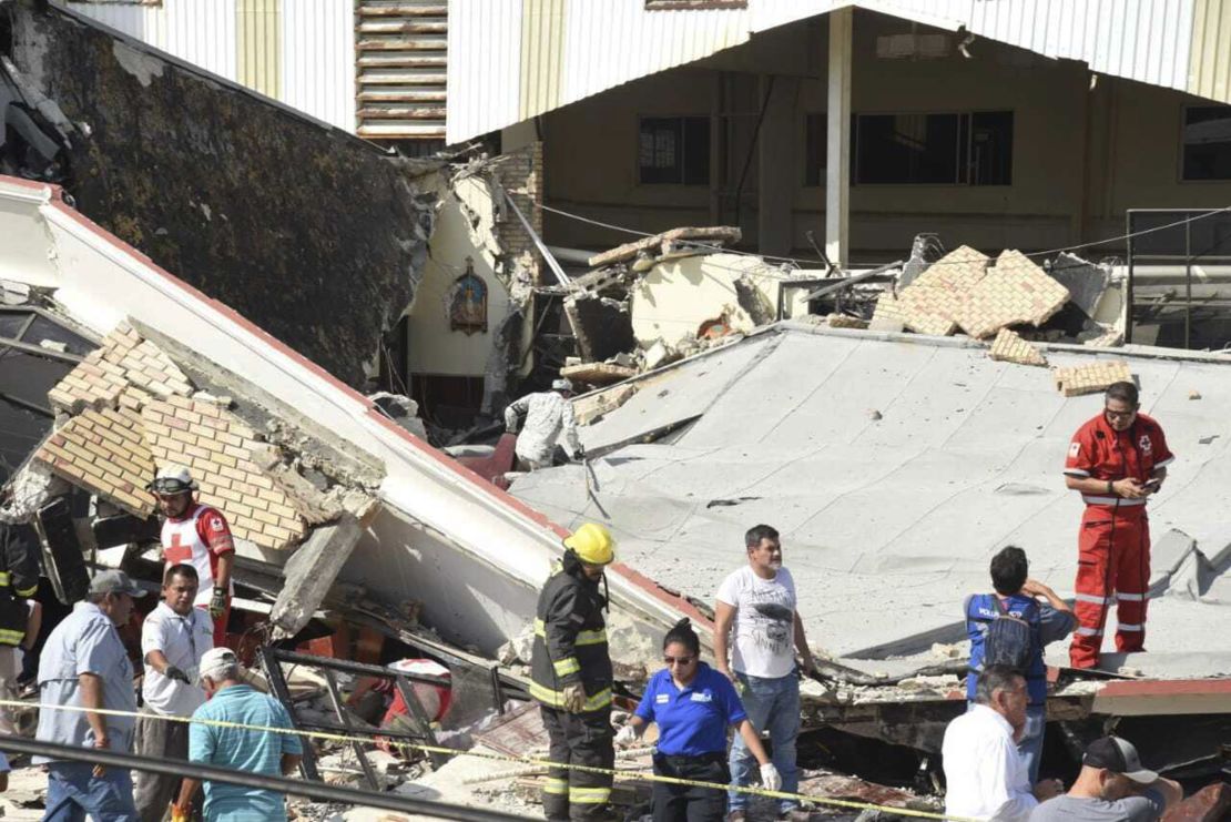 Rescue workers search in the debris for dozens of worshipers missing following the disaster. 