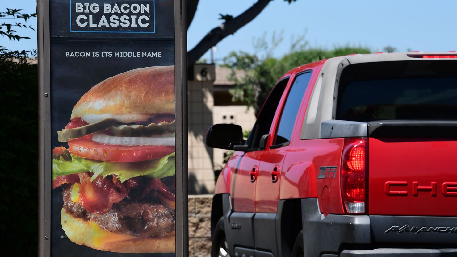 A driver in a vehicle places his order from a drive-thru lane at a Wendy's fast food restaurant in Alhambra, California on May 5, 2020. 