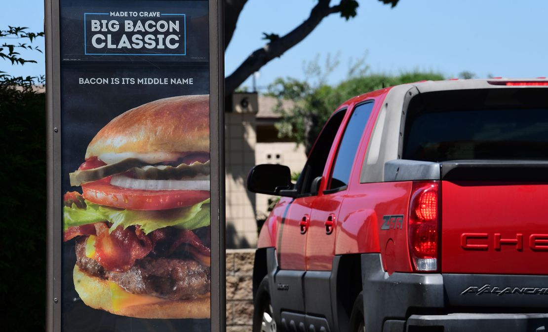 A driver in a vehicle places his order from a drive-thru lane at a Wendy's fast food restaurant in Alhambra, California on May 5, 2020.