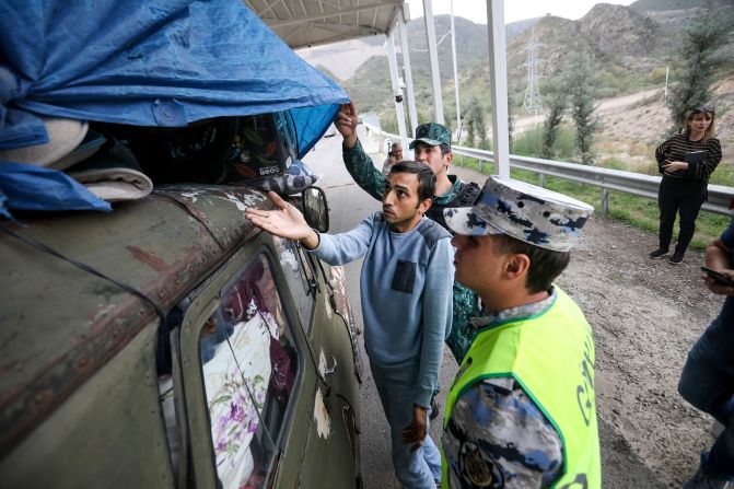 Sergey Astsetryan, an ethnic Armenian resident of Nagorno-Karabakh, shows his belongings as Azerbaijani border guards check his vehicle at military checkpoint on the Lachin corridor on October 1. 