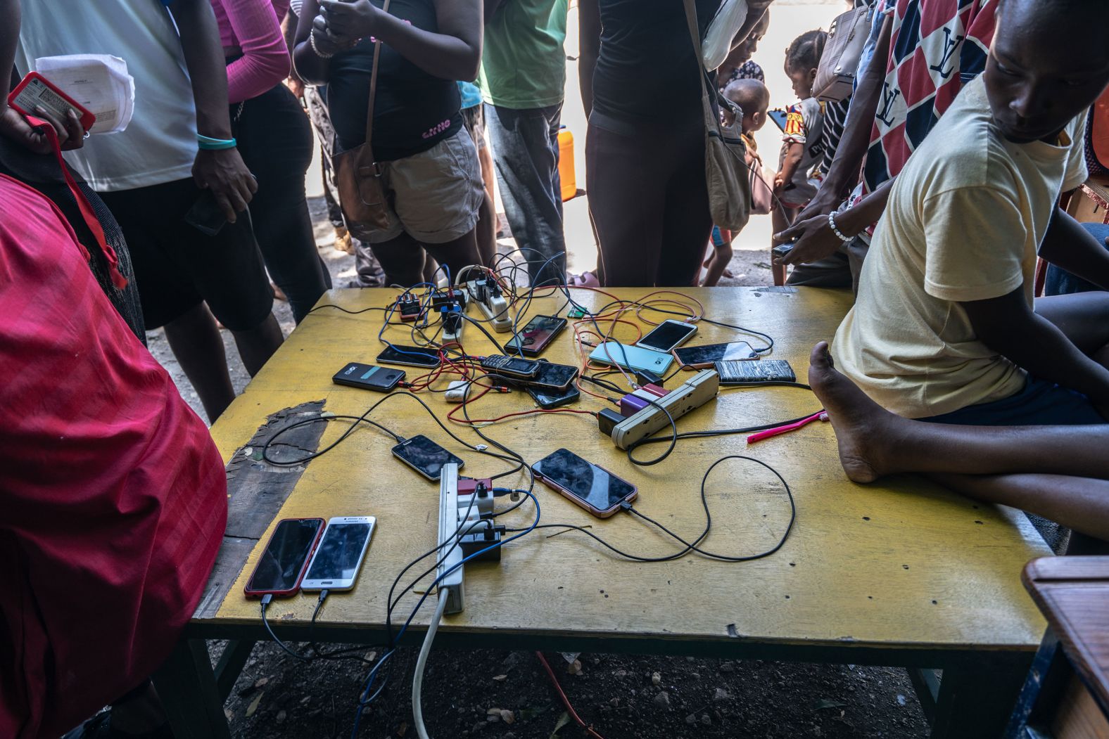 Displaced people charge their phones at a school that has been converted into a displacement camp.
