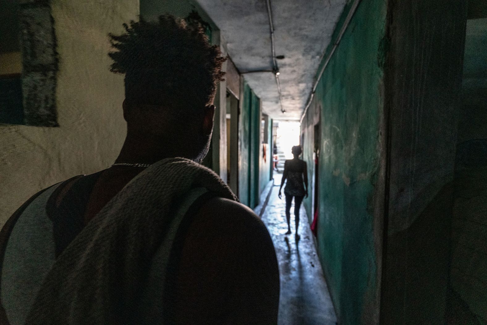 A man who recently fled from his home walks down the corridor of a former school that has been turned into a shelter.
