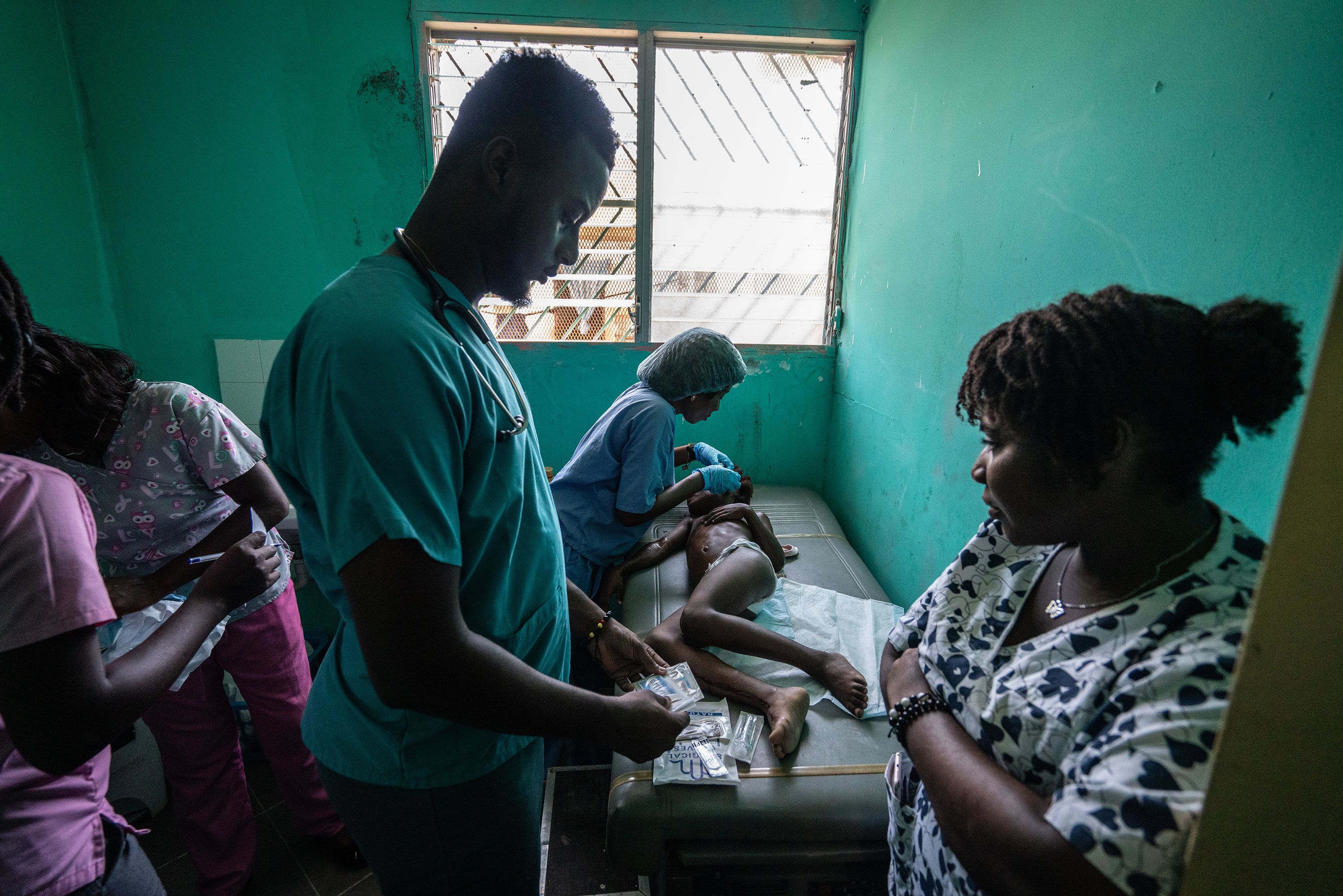 A medical team at the UNICEF-supported Fontaine Hospital help a child who was injured in a traffic accident.