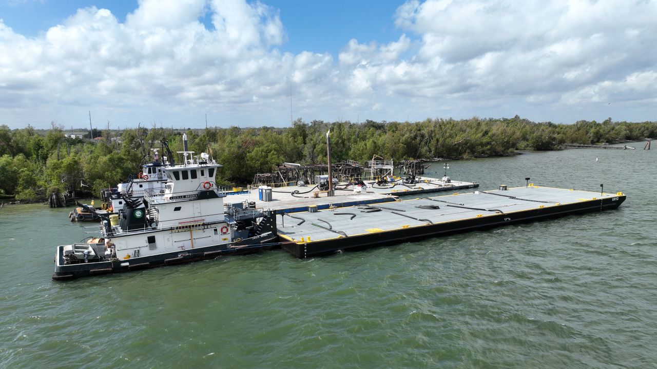 A barge unloads its fresh water cargo at Port Sulphur, Louisiana.