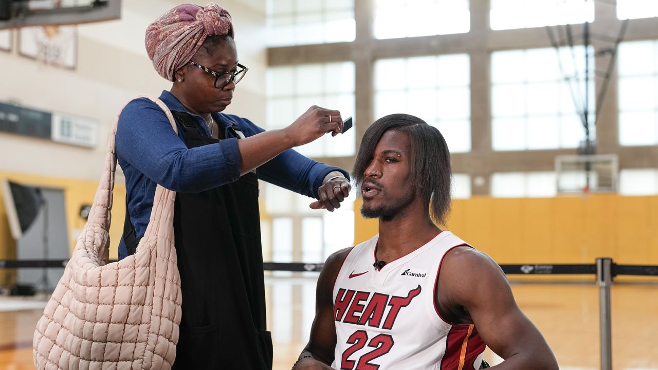 Miami Heat forward Jimmy Butler (22) gets his new hairdo brushed at the start of a TV interview, during the NBA basketball team's media day, in Miami, Monday, Oct. 2, 2023. (AP Photo/Rebecca Blackwell)