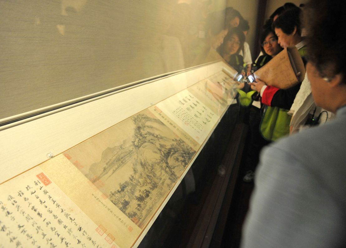 Visitors look at "Dwelling in the Fuchun Mountains" at the National Palace Museum Taipei on June 1, 2011.