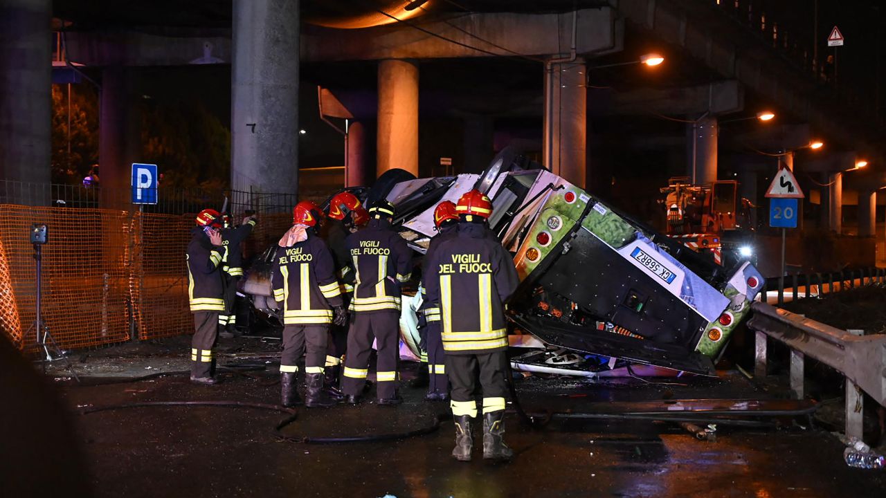 Firefighters work on the site of a bus accident on October 3, 2023 in Mestre, near Venice. 