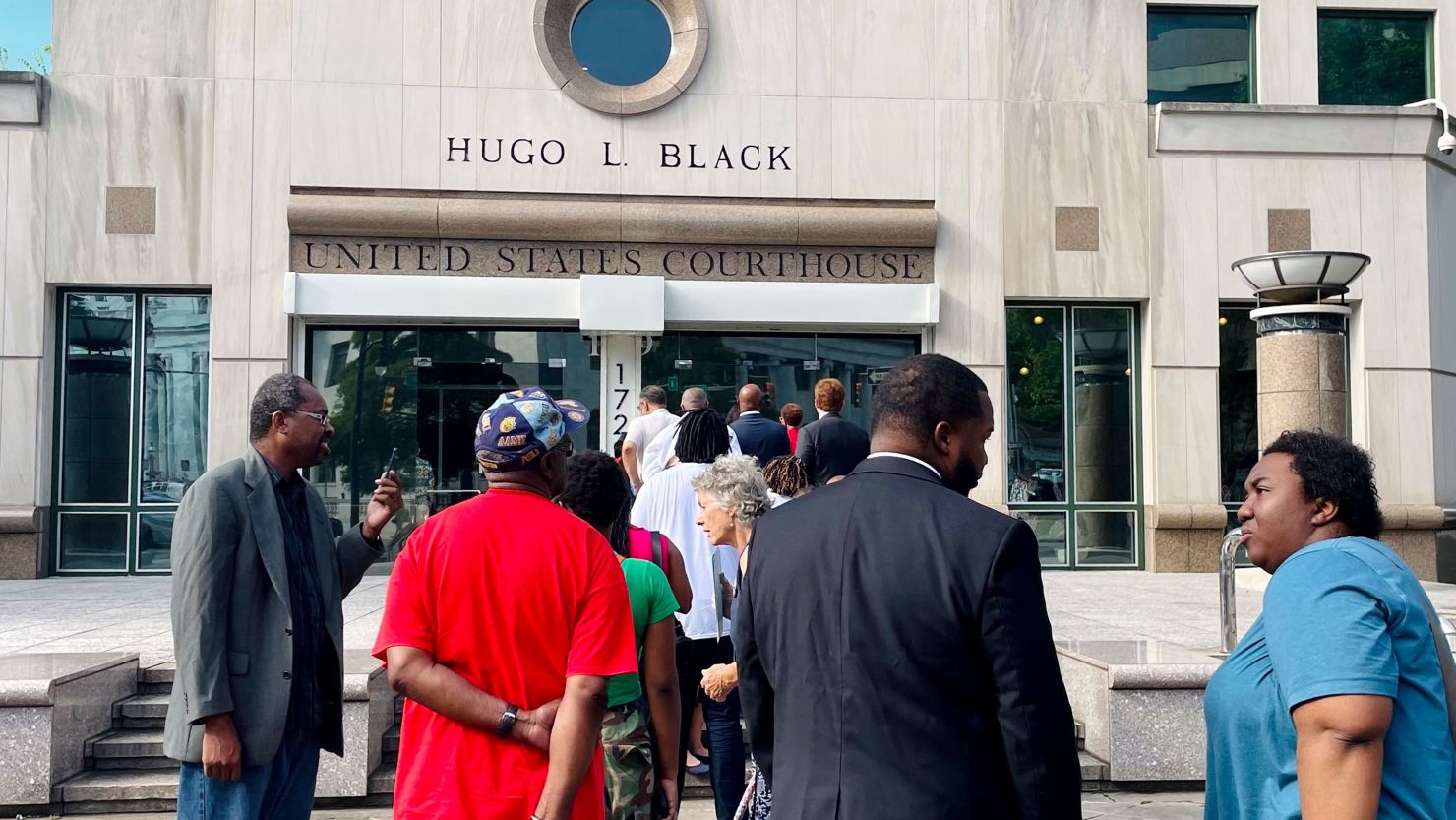 People line up on August 14, 2023, outside the federal courthouse in Birmingham, Alabama, where a three-judge panel was reviewing a new congressional map for the state. 