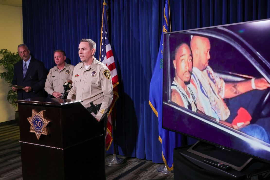 An image on a television monitor shows a photo of Tupac Shakur (L) and Marion "Suge" Knight Jr. in a car in Las Vegas the night Shakur was killed as (L-R) Clark County District Attorney Steve Wolfson, Clark County Sheriff Kevin McMahill and Las Vegas Metropolitan Police Department Lt. Jason Johansson hold a news conference at the LVMPD headquarters on the arrest and indictment of Duane "Keefe D" Davis for the 1996 murder of Shakur on September 29, 2023 in Las Vegas, Nevada. A Nevada grand jury indicted Davis on one count of murder with a deadly weapon in the fatal drive-by shooting of rapper Tupac Shakur.