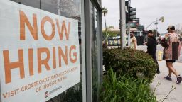 A 'Now Hiring' sign is displayed outside a resale clothing shop on June 2, 2023 in Los Angeles, California.