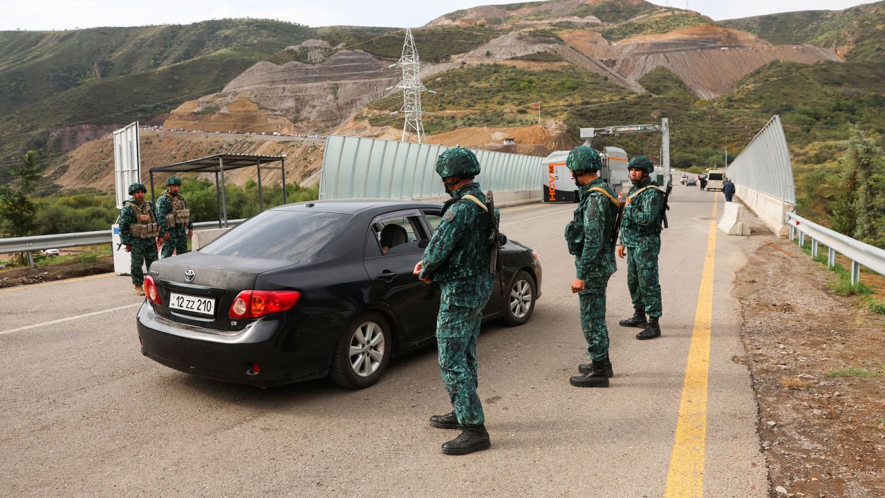 Azerbaijani soldiers stand guard as they stand guard at the Lachin border station, as cars leave Karabakh towards Armenia, on September 26. 