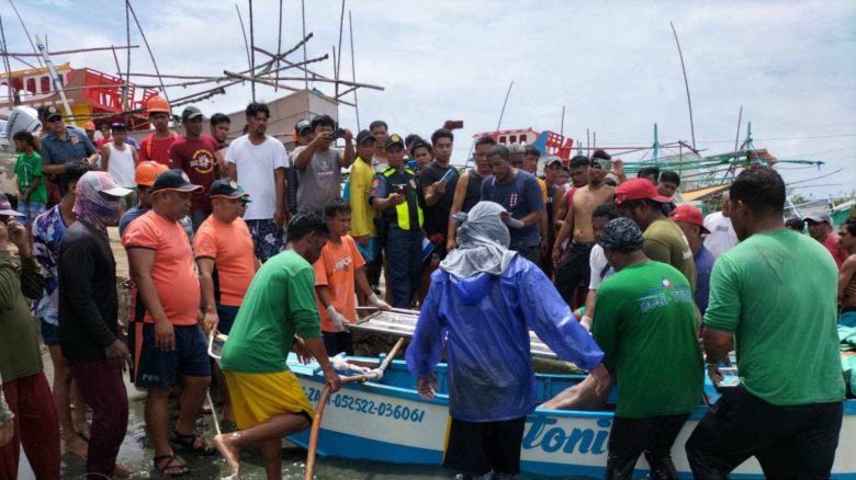 Survivors arrive ashore in the province of Pangasinan on October 3 after what the Philippine coast guard said was a collision between a fishing boat and an "unidentified commercial vessel."
