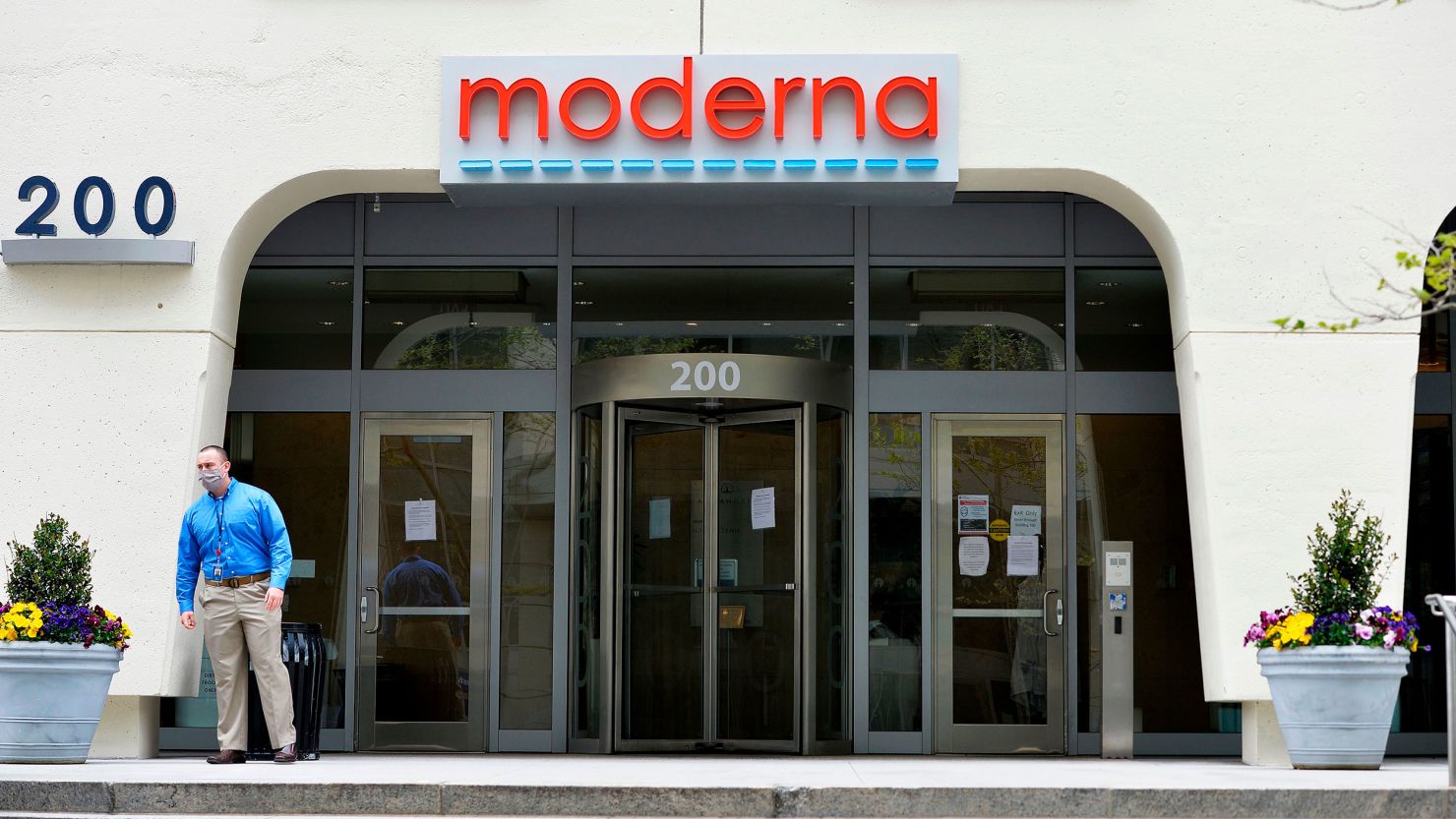 A man stands outside Moderna headquarters in Cambridge, Massachusetts on May 18, 2020. - US biotech firm Moderna reported promising early results from the first clinical tests of an experimental vaccine against the novel coronavirus performed on a small number of volunteers. The Cambridge, Massachusetts-based company said the vaccine candidate, mRNA-1273, appeared to produce an immune response in eight people who received it similar to that seen in people convalescing from the virus. (Photo by Joseph Prezioso / AFP) (Photo by JOSEPH PREZIOSO/AFP via Getty Images)