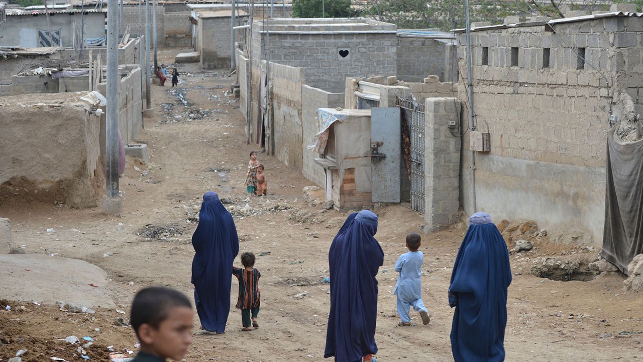 Afghan women walk through a refugee camp in Karachi on September 21.