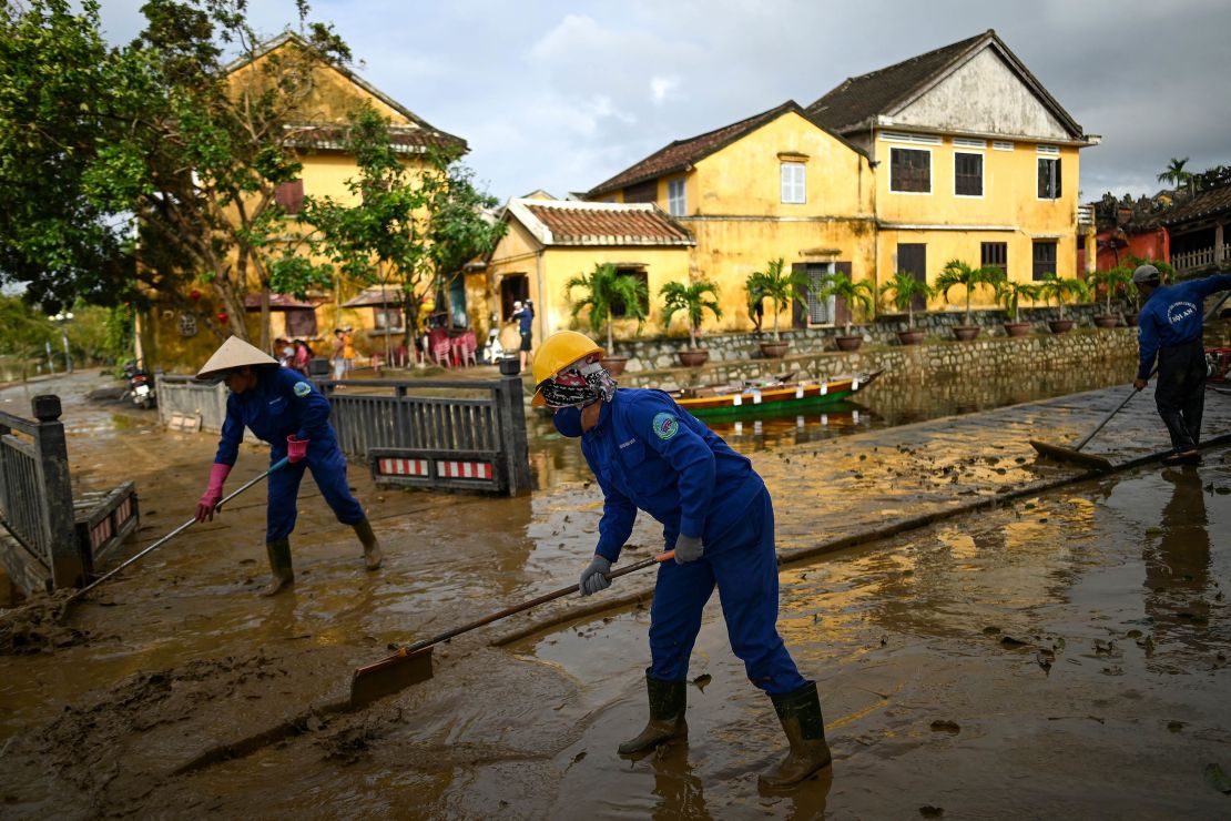 Municipal workers clean up the streets after waters receded in the old city of Hoi An on October 30, 2020, in the aftermath of Typhoon Molave. 