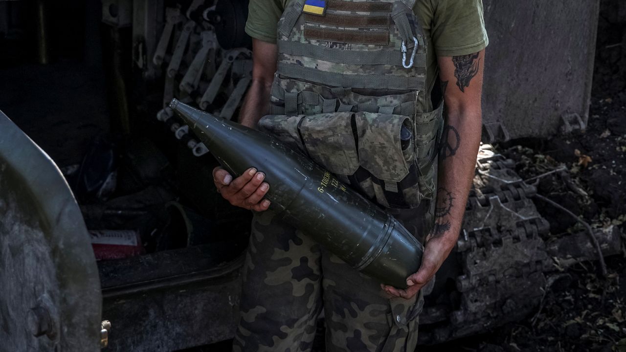 Un militaire ukrainien tient un obus d'artillerie alors qu'il se tient près d'un obusier automoteur avant de tirer sur les troupes russes dans la région de Donetsk en Ukraine, le 26 septembre.