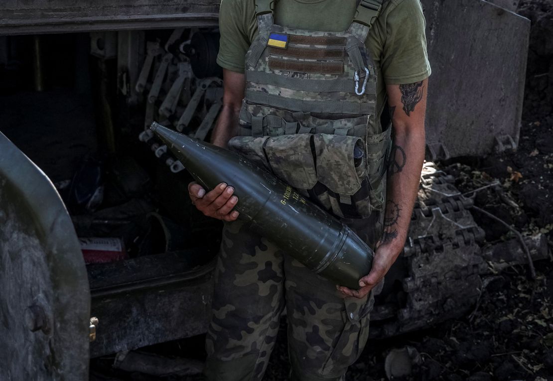A Ukrainian serviceman holds an artillery shell as he stands near a self-propelled howitzer before firing towards Russian troops in the Donetsk region of Ukraine on September 26.