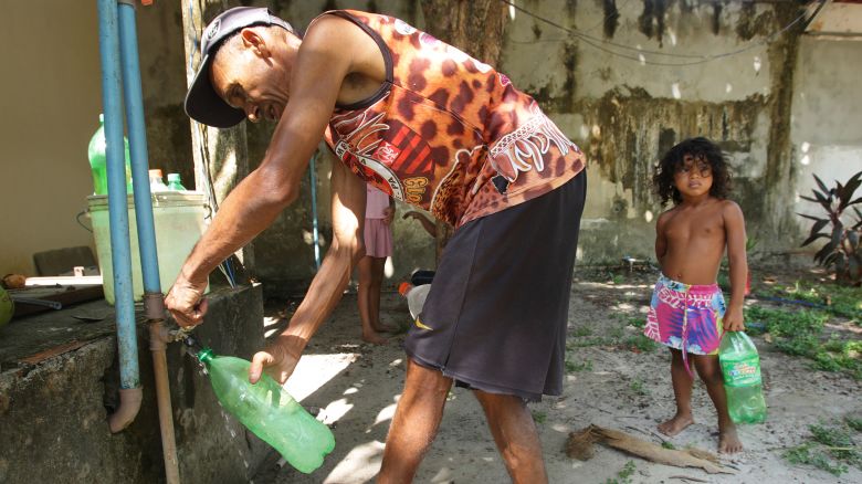 A local fills a plastic water bottle donated by a neighbour during heat wave with temperature 39 degrees Celsius on September 30, 2023 in Soure city at the Marajo island in Brazil. The lack of drinking water in many neighbourhoods is constant due to the neglect of local authorities in Ilha do Marajo. (Photo by Paulo Amorim/Sipa USA)(Sipa via AP Images)