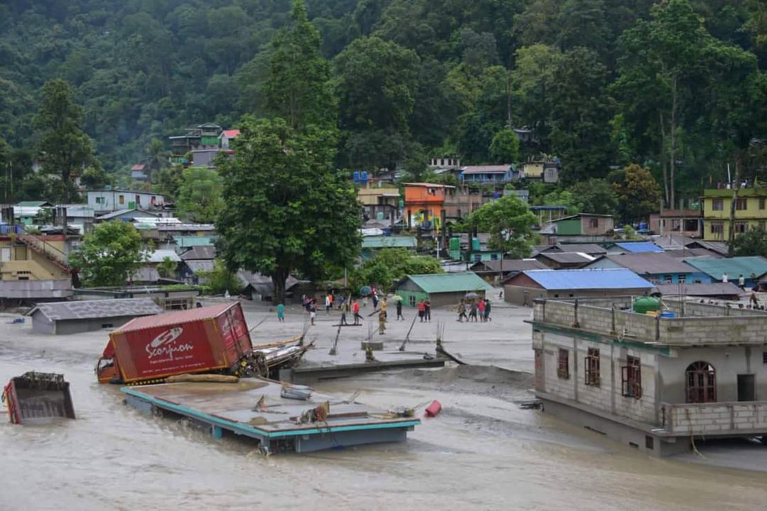 A vehicle lies on top of a submerged building after flash floods triggered by a sudden heavy rainfall swamped the Rangpo town in Sikkim, India, Oct. 5, 2023. 