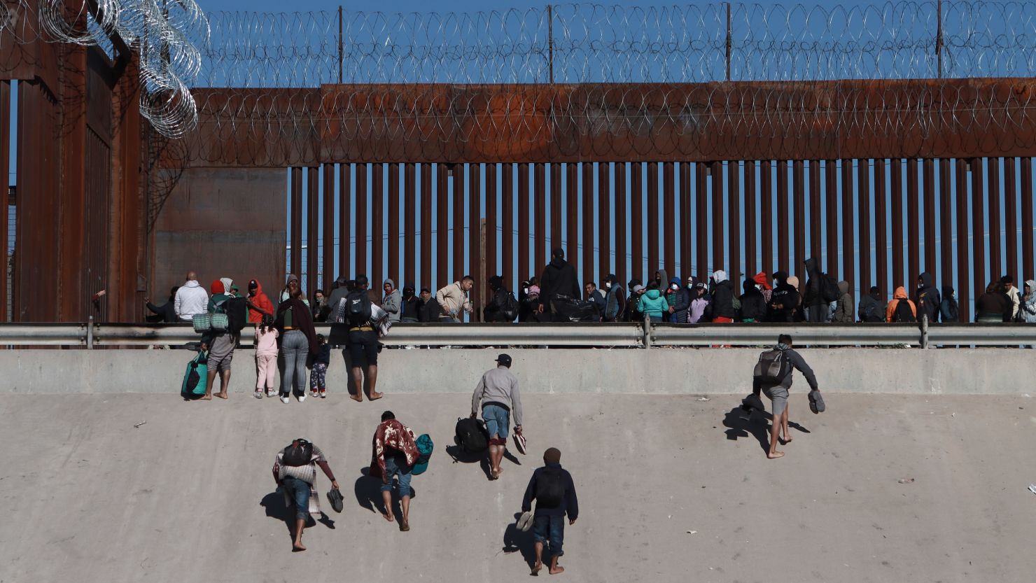 Migrants approach the border wall in Ciudad Juarez, Mexico, on Wednesday, December 21, 2022, on the other side of the border from El Paso, Texas.