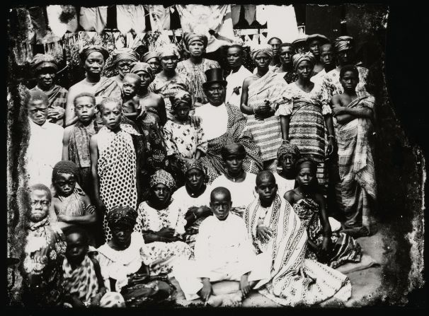 Acolatse's documentary photography gives an insight into life in Togo beyond the capital. This image shows a seated chief wearing a prestige cloth over his left shoulder, surrounded by men, women and children.