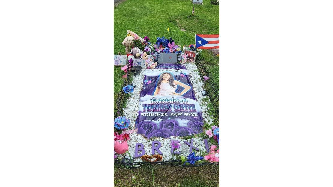 Brexi's image, stuffed animals and other decorations adorn her grave.