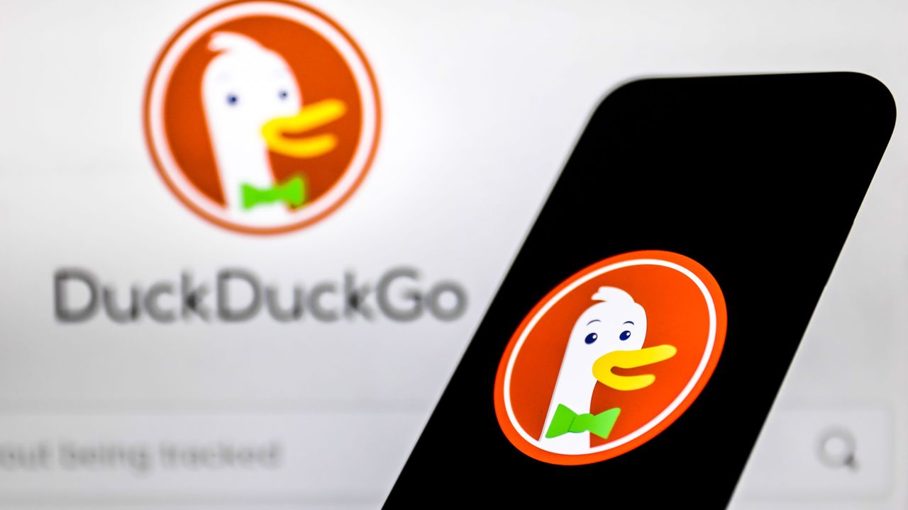 DuckDuckGo logo displayed on a phone screen and DuckDuckGo website displayed on a laptop screen in October 2021.