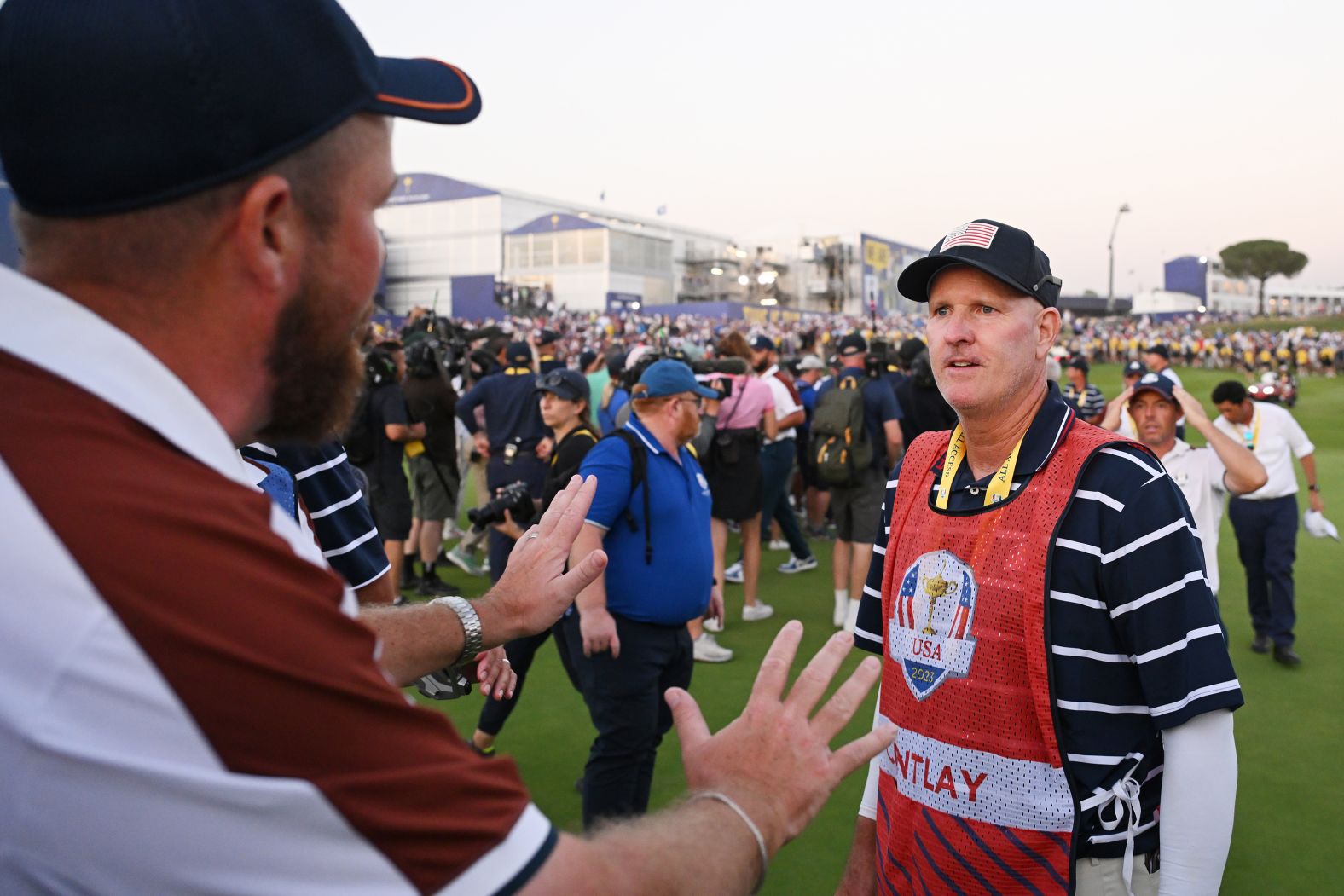 Team Europe golfer Shane Lowry, left, interacts with US caddie Joe LaCava after a <a href="https://www.cnn.com/2023/10/02/sport/rory-mcilroy-angry-caddies-ryder-cup-spt-intl/index.html" target="_blank">heated confrontation during Ryder Cup play</a> on Saturday, September 30. LaCava and European golfer Rory McIlroy, seen here behind LaCava, had an argument on the 18th green at the end of a match. <a href="https://www.cnn.com/2023/10/01/sport/ryder-cup-2023-result-spt-intl/index.html" target="_blank">Europe went on to regain the Ryder Cup</a> on Sunday.