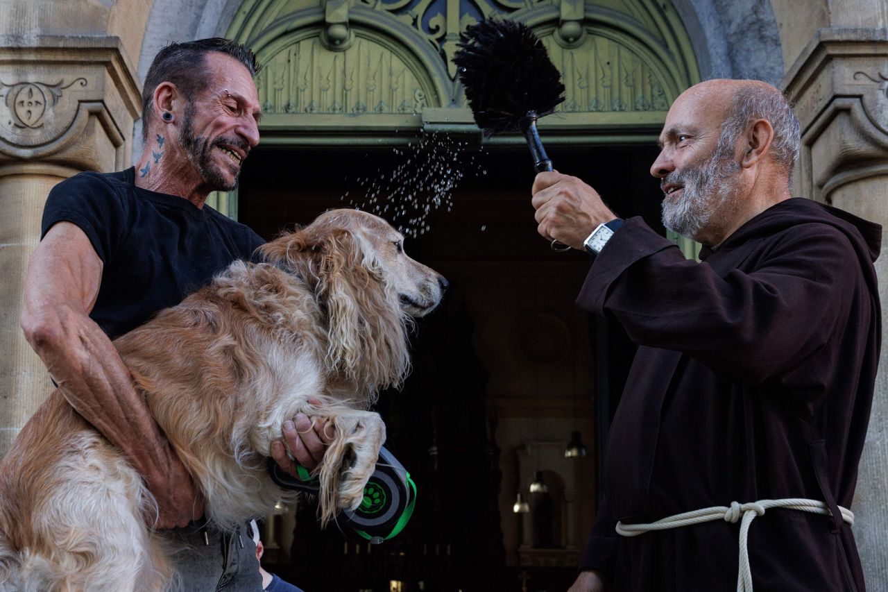 A man has his dog blessed in the Marolles neighborhood in Brussels, Belgium, on Sunday, October 1. The blessing of the animals is an annual tradition there.