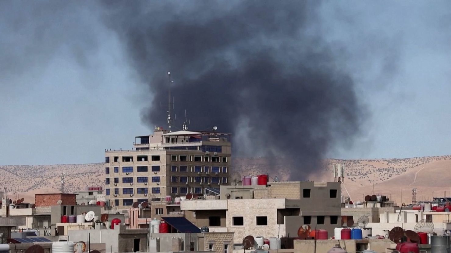 Smoke rises over buildings after a reported strike in Qamishli, Syria.