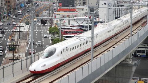A new bullet train, passes over traffic on the streets below in Nagasaki on the first day of operations on Japan's Kyushu island on September 23, 2022. 