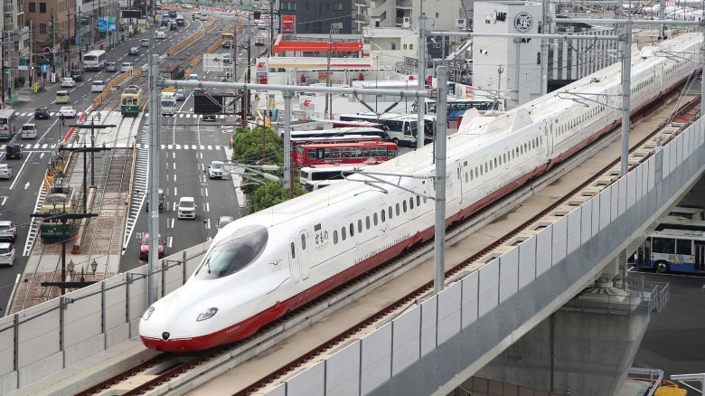 A new bullet train, passes over traffic on the streets below in Nagasaki on the first day of operations on Japan's Kyushu island on September 23, 2022. 