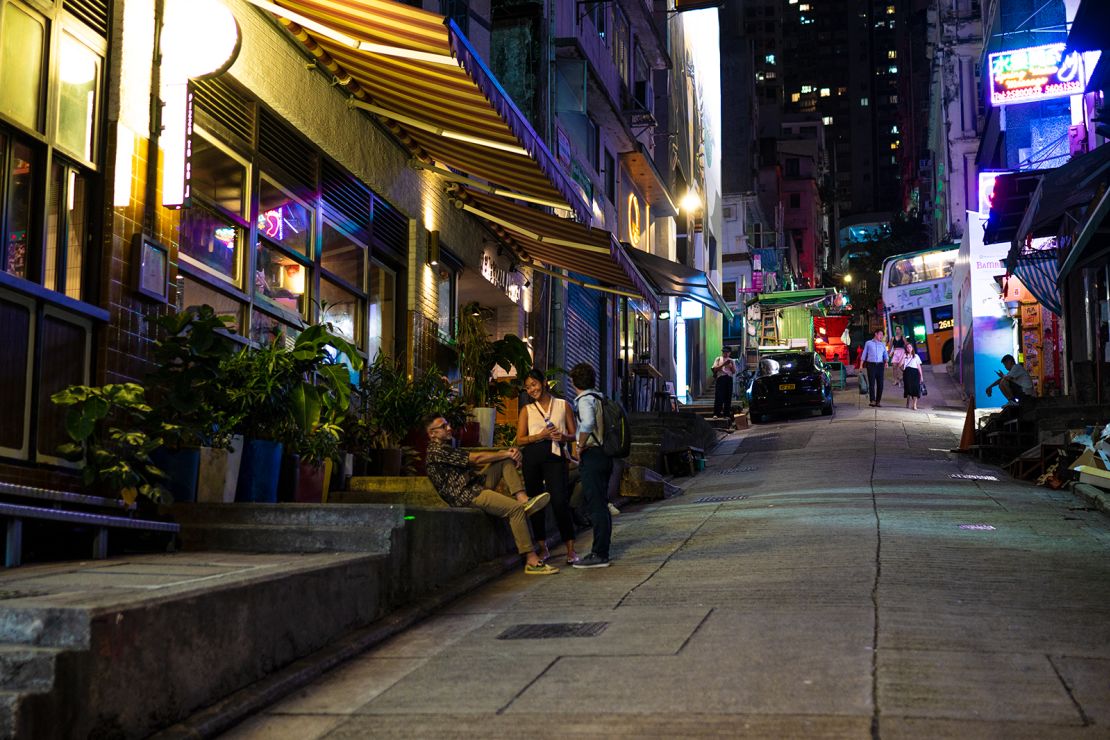People gather outside a restaurant on a near-empty street in the Soho area of Hong Kong.