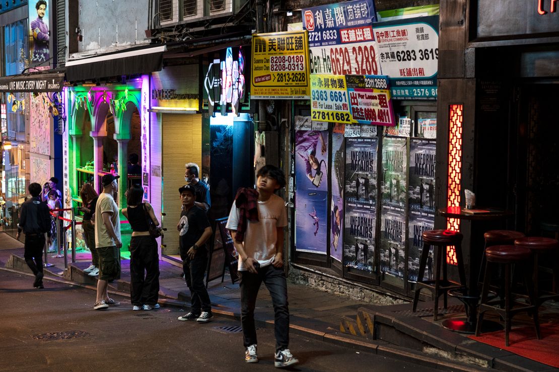 A man walks past a closed bar along a near-empty street in the Soho area of Hong Kong.