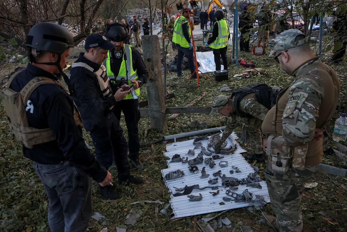Police and military experts work at the site of a Russian military strike in Hroza.