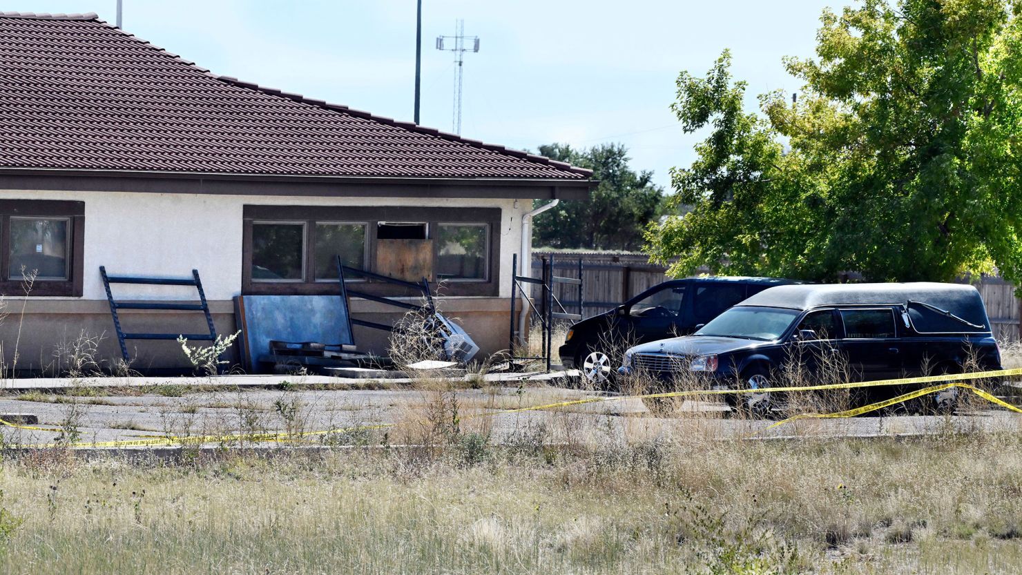 A hearse and debris can be seen at the rear of the Return to Nature Funeral Home in Penrose, Colorado.