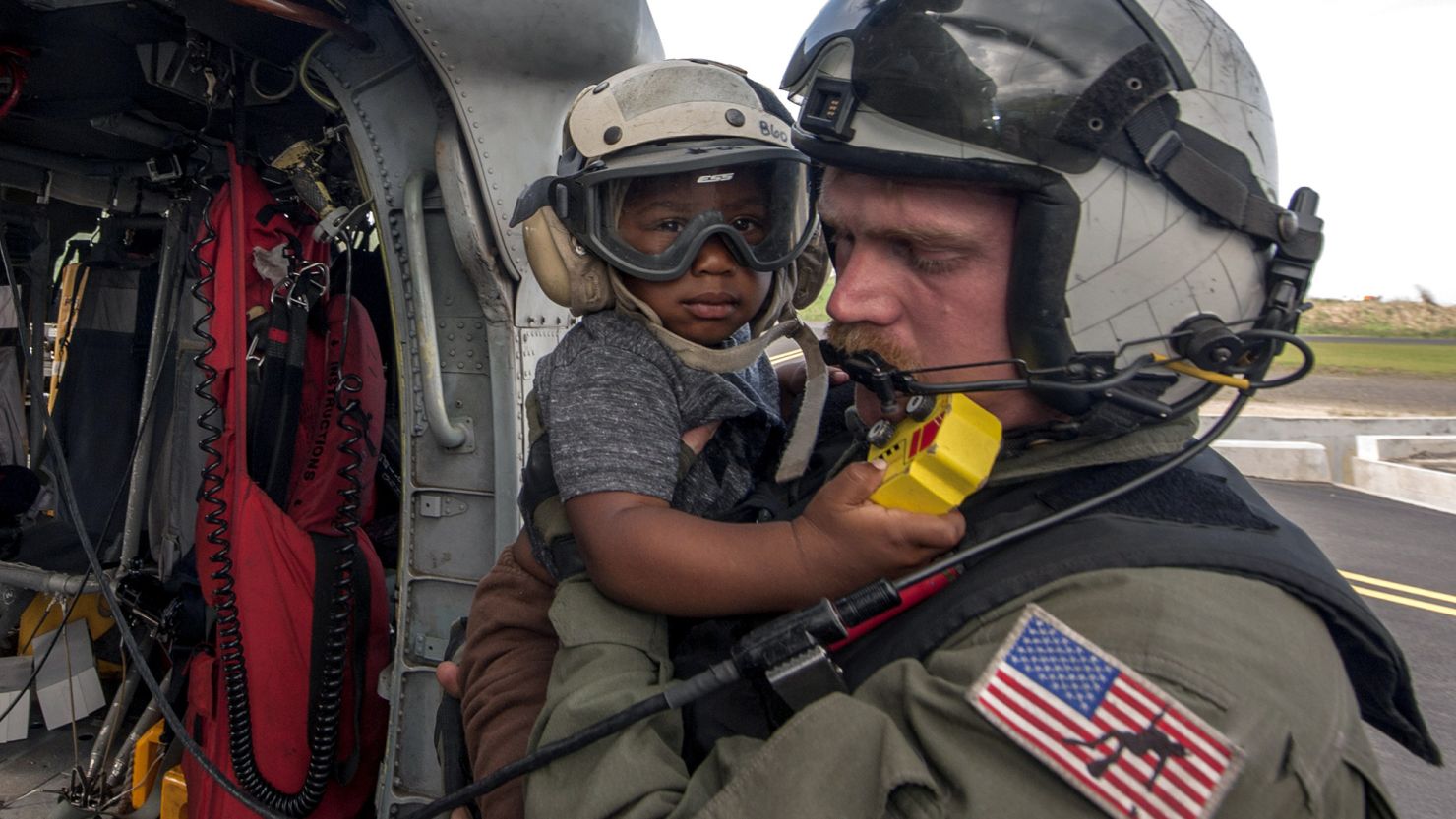 A US Naval Aircrewman carries an child evacuated from the island of Dominica following the landfall of Hurricane Maria on September 27, 2017.
