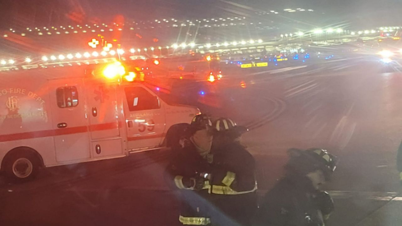 Looking out a window from his seat on the plane, passenger Kevis Mitchell took his photo of emergency responders arriving after the collision.