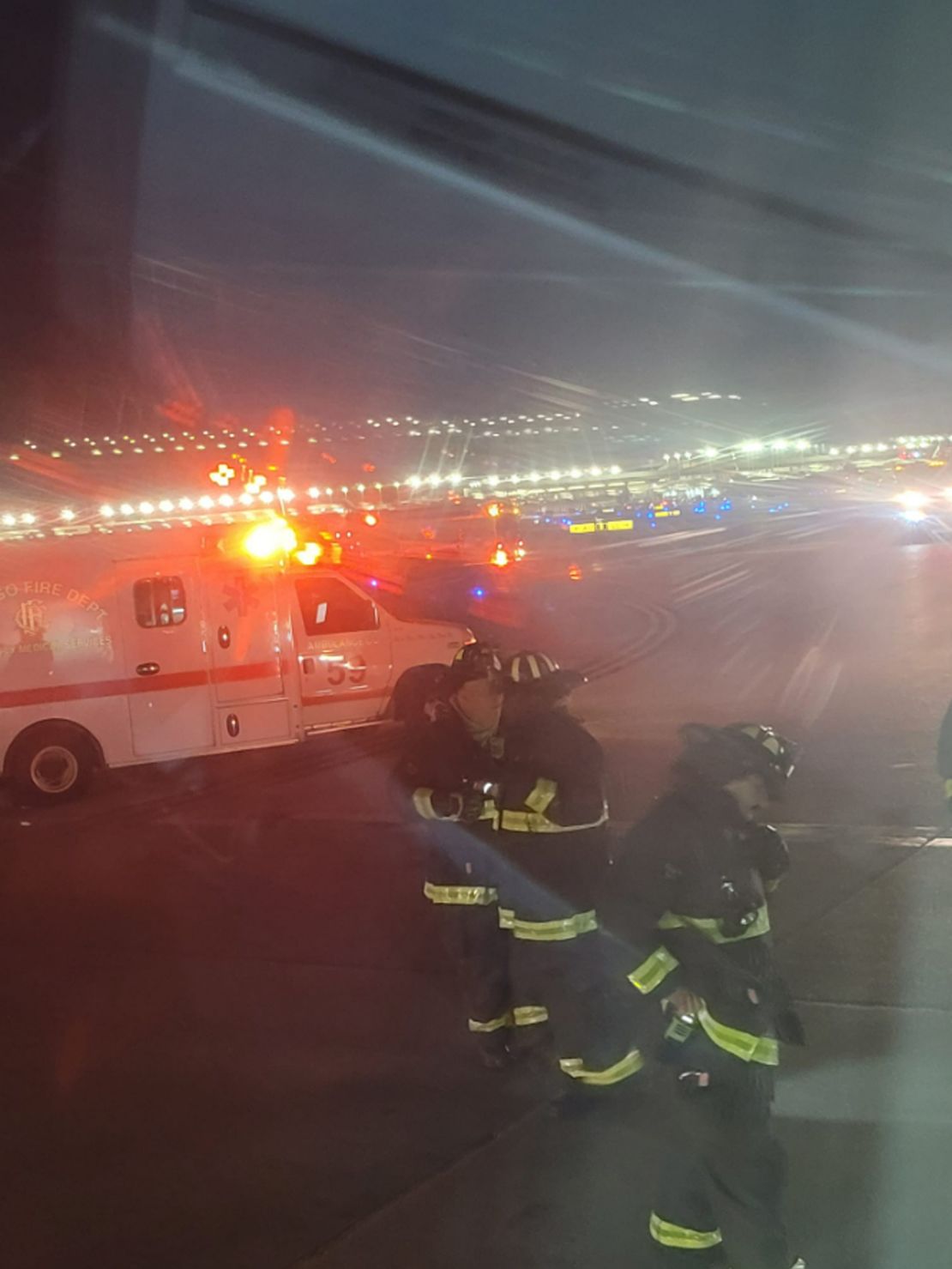 Looking out a window from his seat on the plane, passenger Kevis Mitchell took his photo of emergency responders arriving after the collision. 