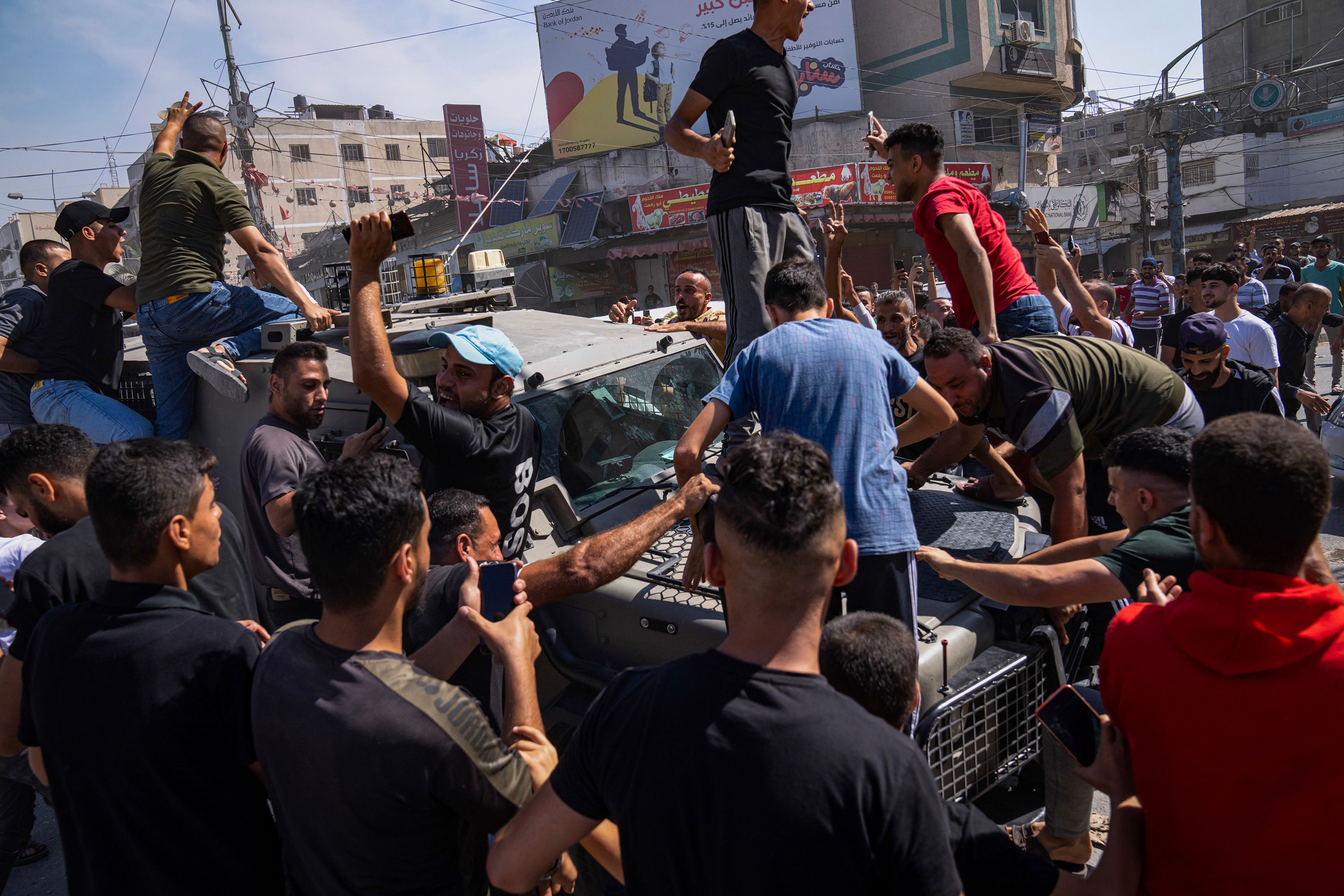 Palestinians gather around an Israeli army vehicle that Palestinian militants drove from Israel into Gaza on October 7.