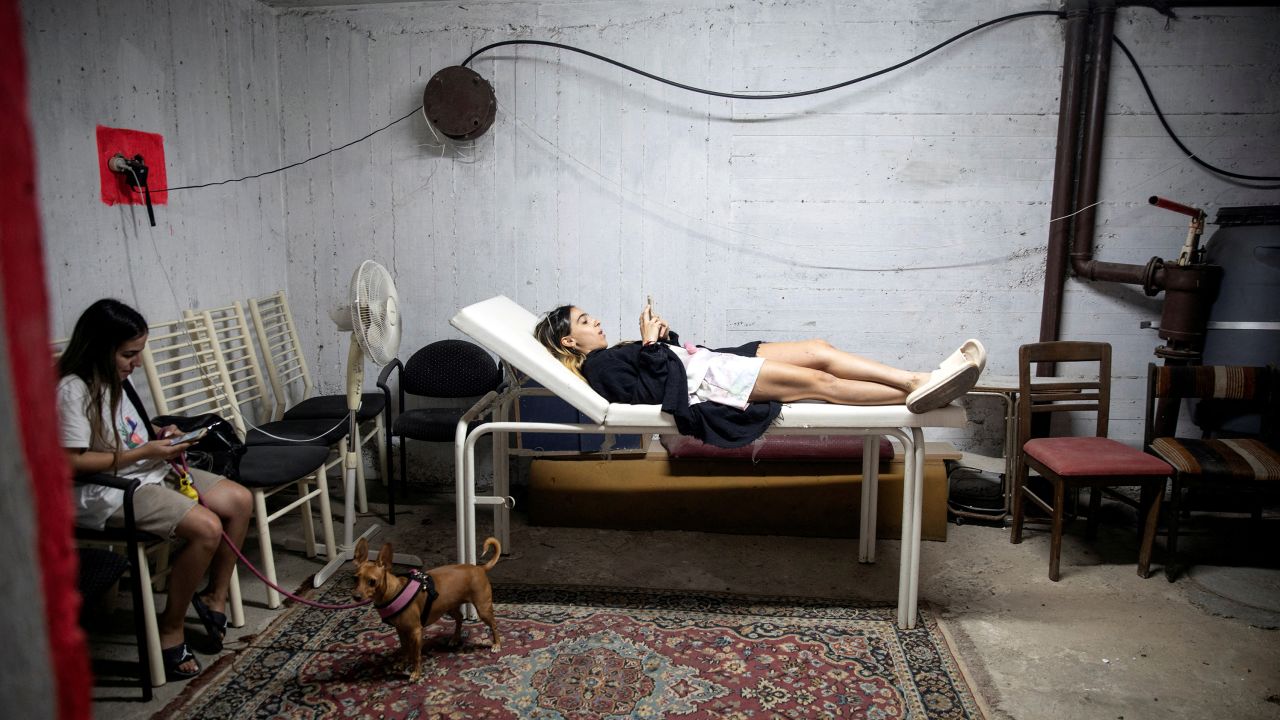 Israelis take cover in a bomb shelter as rockets are launched from the Gaza Strip.
