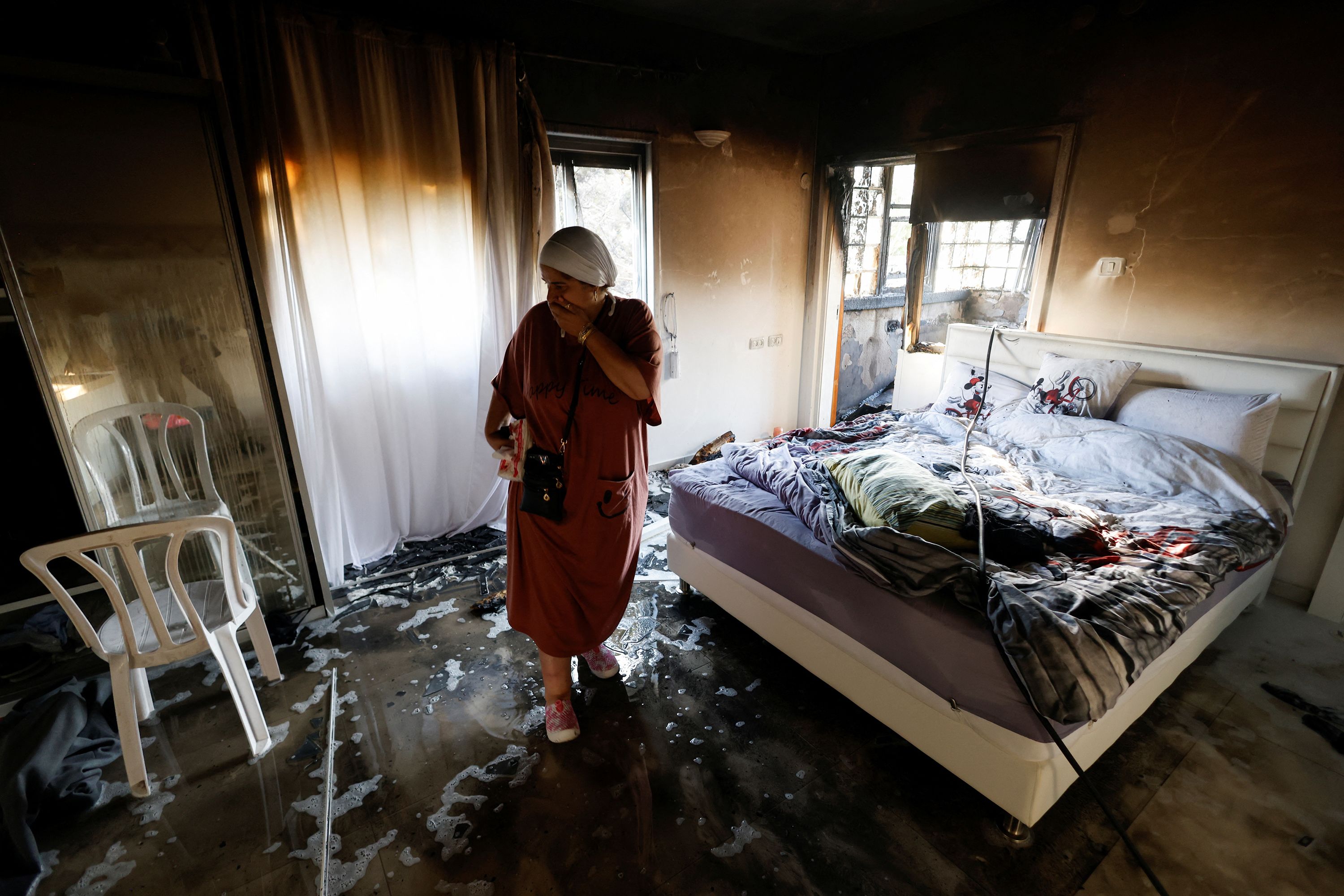 A woman stands in a room damaged by rockets in Ashkelon on October 7.