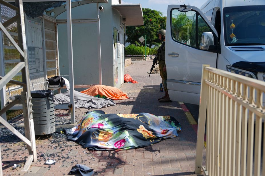 An Israeli soldier stands by the bodies of Israelis killed by Palestinian militants in Sderot on Saturday.