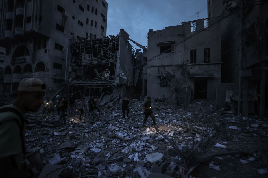 Palestinians inspect damaged buildings in Gaza after Israeli air strikes on Saturday.