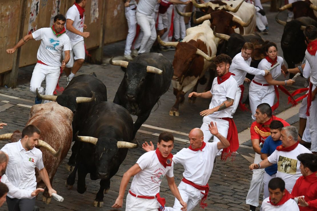 Thousands take part in bull run through streets of Spain - and