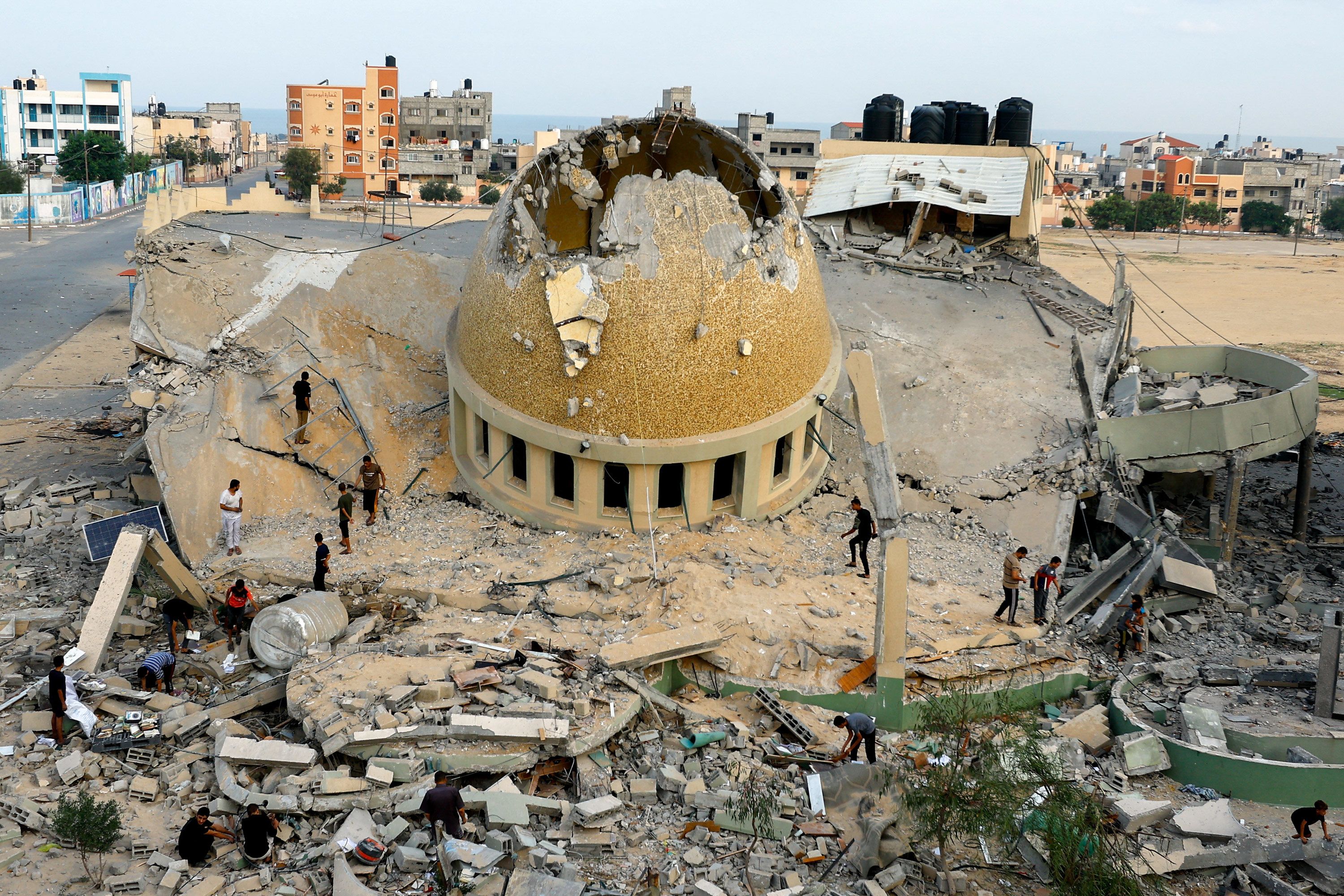 Palestinians inspect a mosque destroyed by Israeli airstrikes in Khan Younis, Gaza, on October 8.